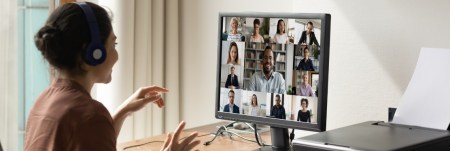 A woman is on a video conference call at her desk in an office.
