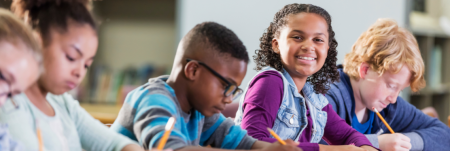 A group of students writing at their desks.
