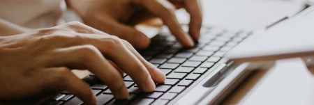 Hands typing on a keyboard.
