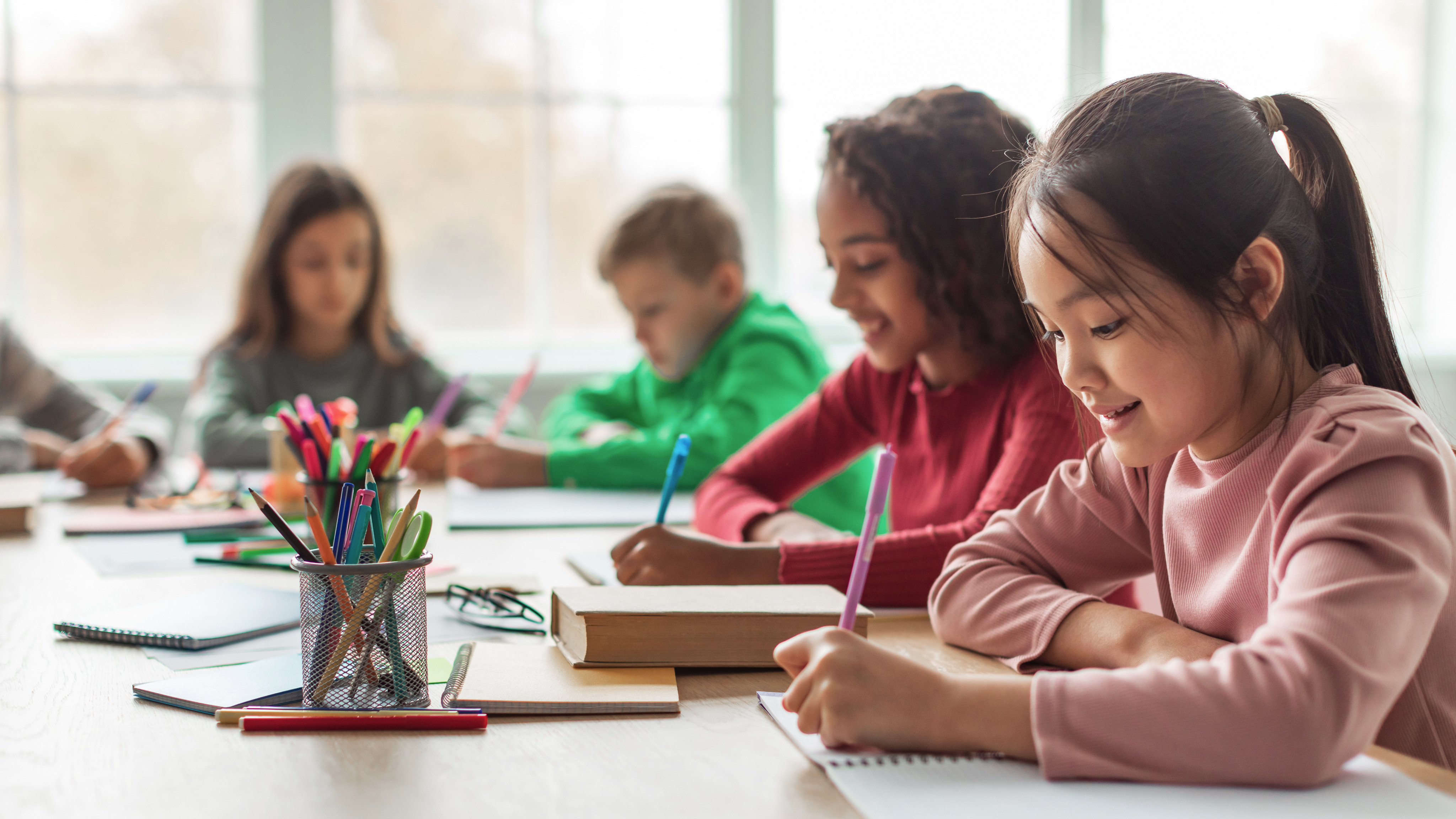 Children working on drawing and writing activities in a classroom