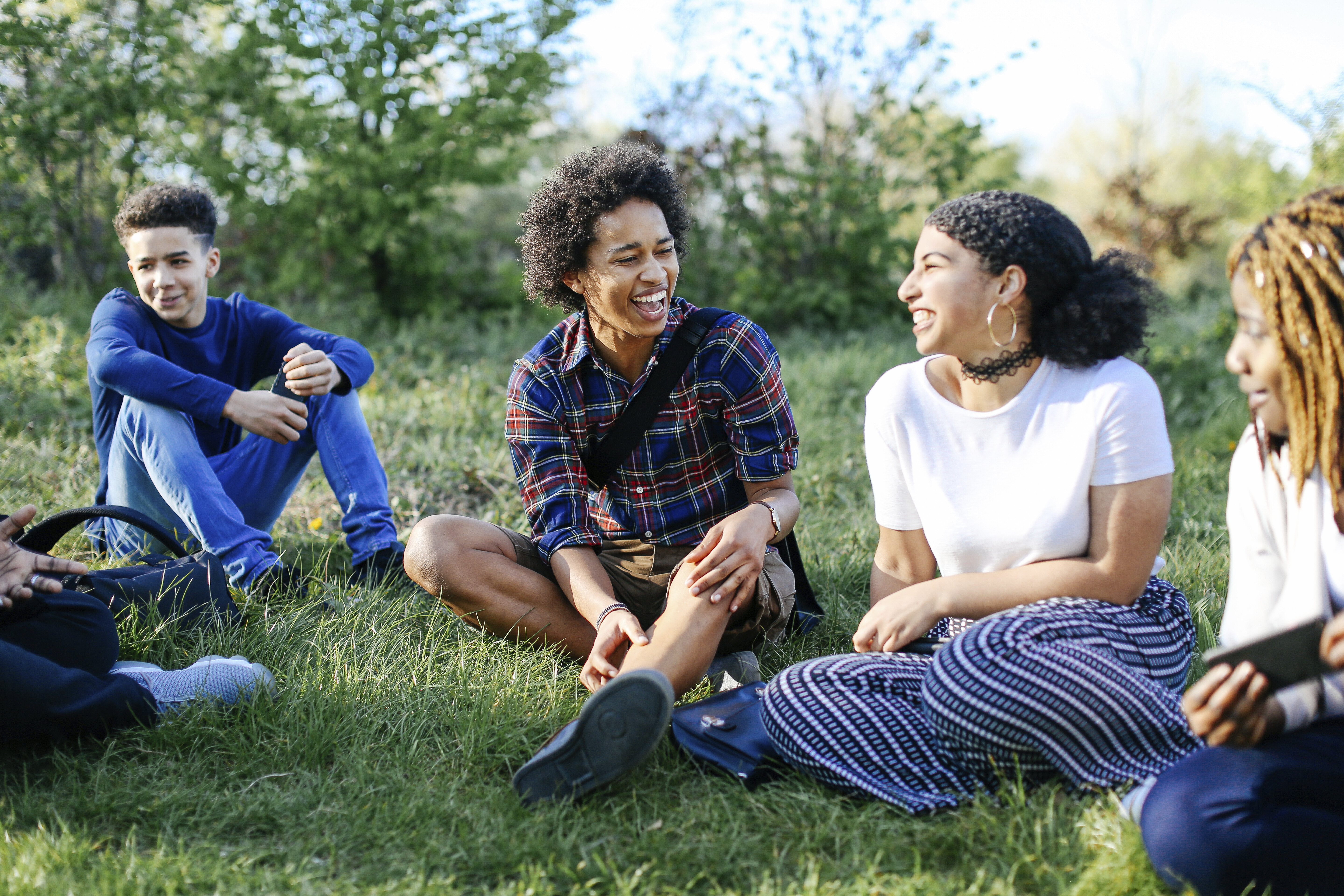 Group of friends sitting on grass, laughing Group of friends sitting on grass, laughing